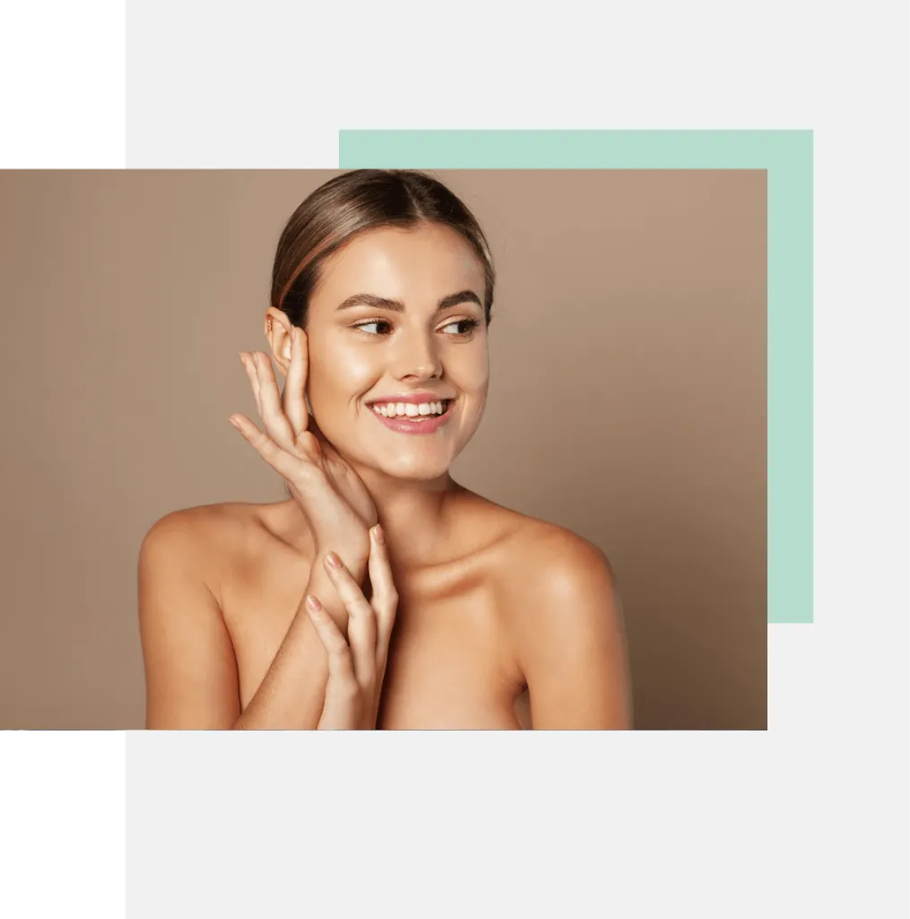 A smiling young woman with a natural, glowing complexion poses with one hand on her cheek and the other touching her chin. She has long, straight hair and is set against a minimalistic background featuring soft pastel colors. The image highlights her radiant skin and cheerful expression, emphasizing beauty and self-care. This visually appealing portrait is ideal for beauty or skincare-related content, promoting a sense of positivity and confidence.
