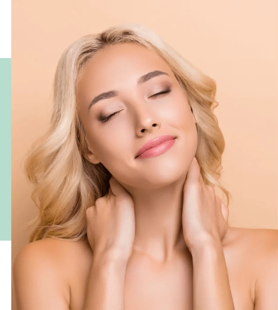 A woman with long, wavy blonde hair is smiling softly with her eyes closed, showcasing a natural makeup look. She gently touches her neck with both hands against a warm peach-colored background. This image conveys a sense of tranquility and beauty, perfect for promoting skincare or wellness products. The soft lighting highlights her features, emphasizing a fresh and radiant complexion. Ideal for beauty blogs, skincare tutorials, or wellness campaigns focused on self-care and relaxation.